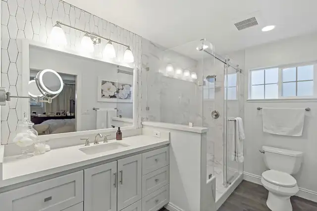 Orange County bathroom remodel with a white shaker vanity, quartz top, hexagon tile accent wall and a marble-look walk-in shower with frameless glass