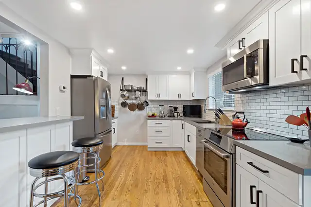 Orange County galley kitchen remodel with white shaker cabinets, gray quartz counters, subway tile backsplash and oak floors